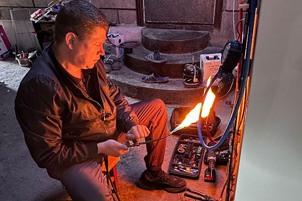 Мастер Павел за работой по ремонту холодильника